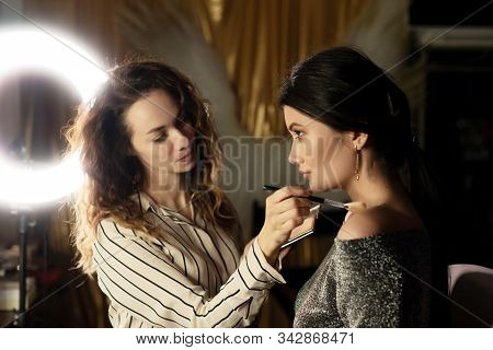 Make-up Artist With Long Hair Puts Powder On The Shoulders Of The Model