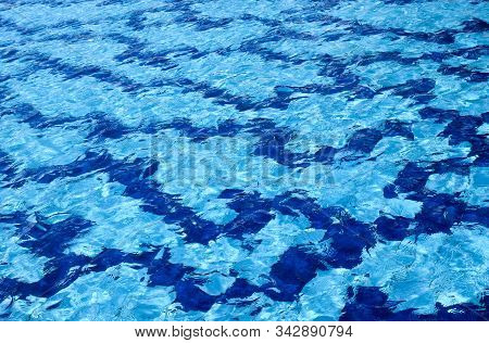 The Water Surface Of The Swimming Pool Turquoise Color, Illuminated By The Sun