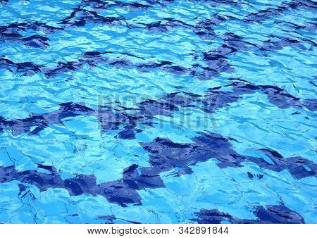The Water Surface Of The Swimming Pool Turquoise Color, Illuminated By The Sun
