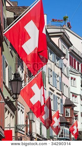 Gamle gade Augustinergasse i Zürich dekoreret med schweiziske flag
