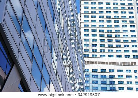 Geometric Reflection: Partly Cloudy Sky Reflected By Window Panes Of Office Building. Surface Of Gla