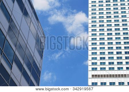 Geometric Reflection: Partly Cloudy Sky Reflected By Window Panes Of Office Building. Surface Of Gla