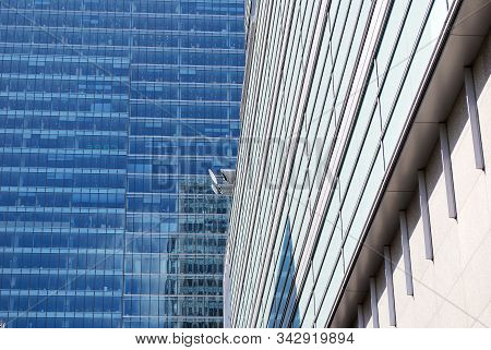 Geometric Reflection: Partly Cloudy Sky Reflected By Window Panes Of Office Building. Surface Of Gla