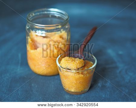 Pike Caviar In A Glass Jar. A Wooden Spoon Scoops Up Caviar. Blue Table Or Background.
