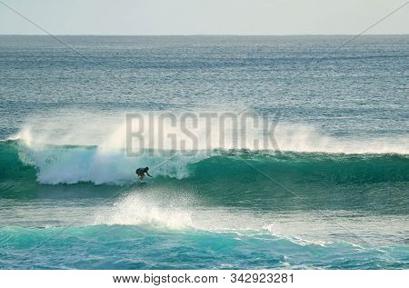Young Surfer Riding On The Breaking Waves In Pacific Ocean At Hanga Roa, Easter Island, Chile