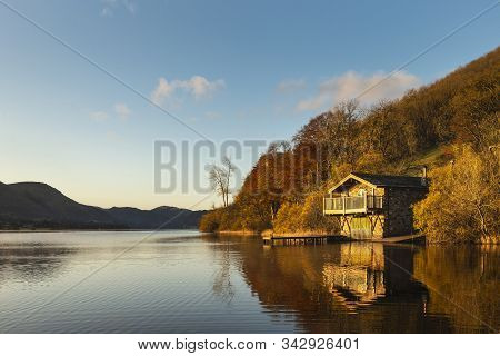 Stunning Sunrise Autumn Fall Landscape Image Of Ullswater In Lake District With Golden Sunlight