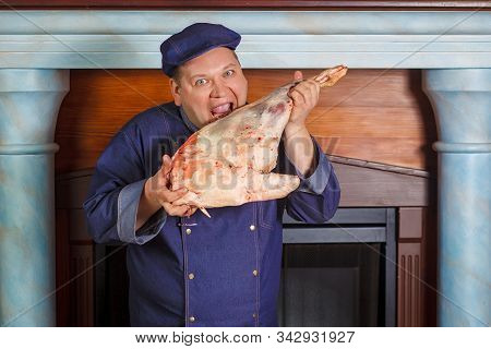 Half Legth Shot Of Thoughtful Male Chef, Holds Very Big Red Raw Piece Of Meat, Needs To Chop For Pre