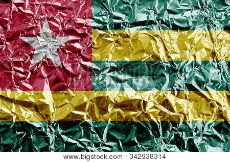 Togo Flag Depicted In Paint Colors On Shiny Crumpled Aluminium Foil Closeup. Textured Banner On Roug
