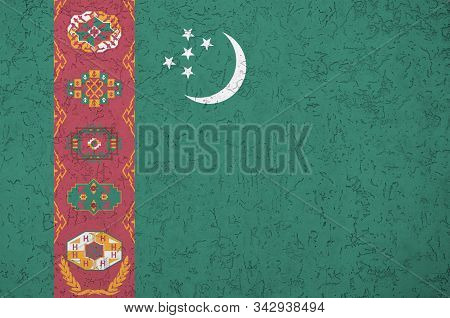 Turkmenistan Flag Depicted In Bright Paint Colors On Old Relief Plastering Wall. Textured Banner On 