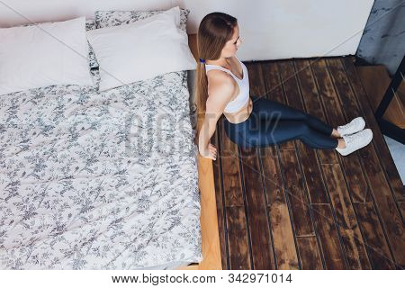 Attrctive Fitness Woman Doing Stretching Exercises At Home, As Part Of A Healthy Lifestyle Without G