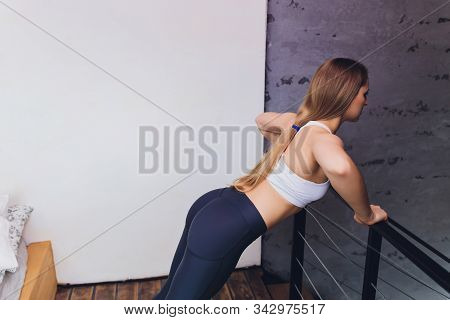 Attrctive Fitness Woman Doing Stretching Exercises At Home, As Part Of A Healthy Lifestyle Without G