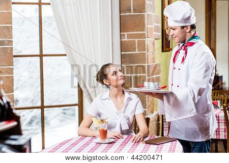 Chef bringt eine Schüssel hübsche Frau in einem restaurant