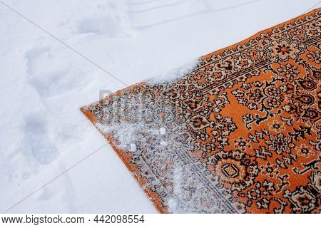 Carpet Is Lying Onsnow. Old Persian Carpet In Red Shades Of Color Is Turned Upside Down And Sprinkle