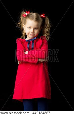 Cute Blonde Little Girl Standing On Black Backdrop. Charming Smiling Girl With Cute Ponytails Hairst