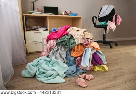 Pile Of Carelessly Scattered Clothes On Floor.
