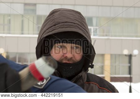 A Portrait Of A Fitter With A Hood On His Head