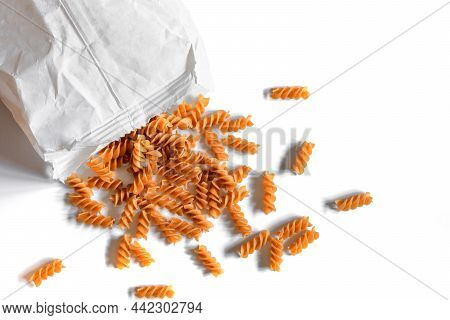Whole Grain Eggless Rye Fusilli Pasta On A White Background Spilled Out Of White Paper Bag