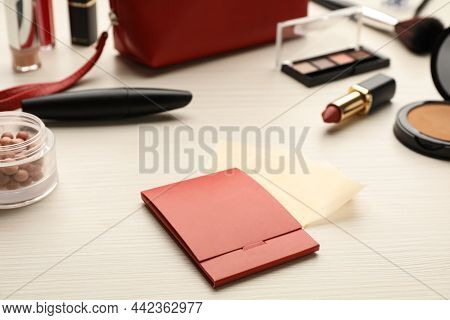Package With Facial Oil Blotting Tissues And Makeup Products On White Wooden Table. Mattifying Wipes