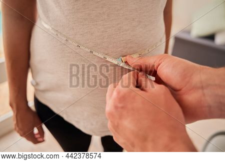 Caucasian Male Doctor Measuring Belly Of Pregnant Woman