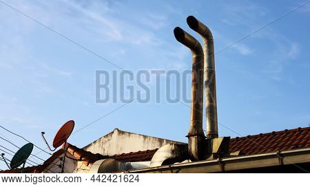 Double Ventilation Pipes On The Roof. Old Rusty Metal Exhaust Pipe With Satellite Dish On The Roof A