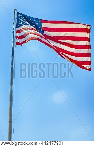 American Travel Destinations. National  American Flag On Pole Against Blue Sky In Arizona In The Uni