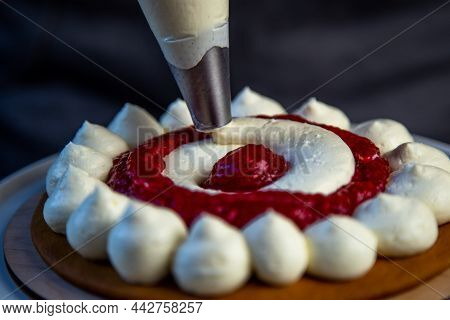 The Baked Cake Cake Lies On A Wooden Substrate And On A White Stand, The Cake Is Decorated With Whit