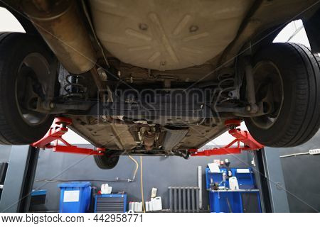 Close-up Of Car Lifted In Maintenance Service To Check Condition, Undercarriage Of Automobile. Botto