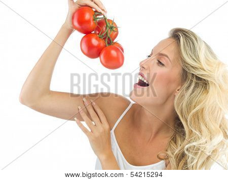 portrait of attractive  caucasian smiling woman isolated on white studio shot eating tomato