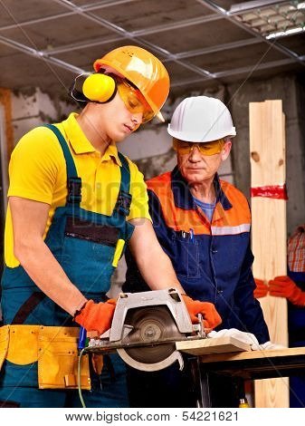Happy group people  builder with circular saw.
