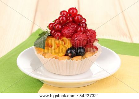 Dulcet cake with fruit and berries on wooden table