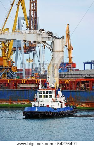 Tugboat assisting bulk cargo ship