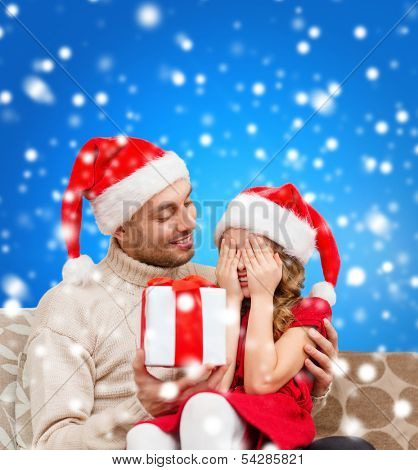 family, christmas, x-mas, winter, happiness and people concept - smiling daughter with closed eyes waiting for a present from fathe