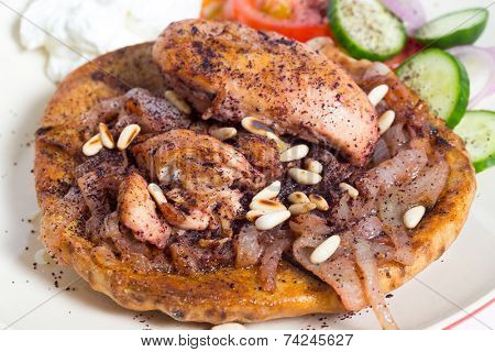 Musakhan, traditional Palestinian sumac chicken, on a plate with a salad and yoghurt,high angle