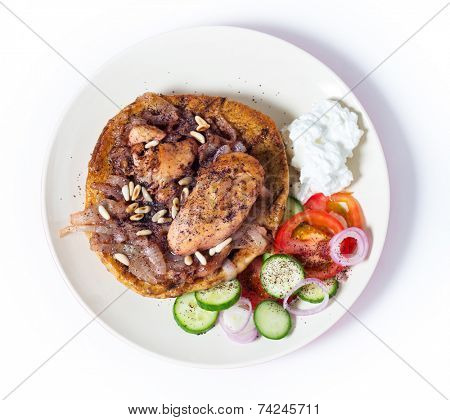 Musakhan, traditional Palestinian sumac chicken, on a plate with a salad and yoghurt, from above