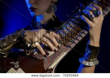 Beautiful Young Indian Woman In Traditional Clothing With Oriental Jewelry Playing The Sitar