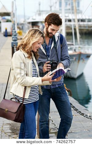 tourist couple with guide book on vacation