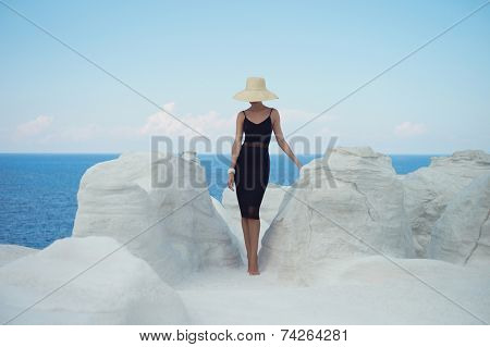 Fashion photo of beautiful lady in hat in an unusual landscape