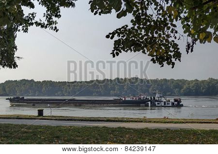 Tugboat with ship pass along the riverside park in Ruse town