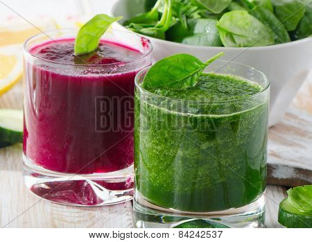 Glasses Of Freshly Squeezed Vegetable Juices On Wooden Table.