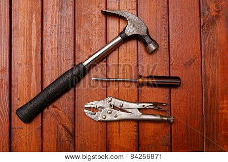 Hammer and other tools on wood background