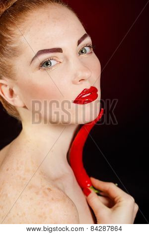 Sexy brunette girl with red cayennes isolated on black
