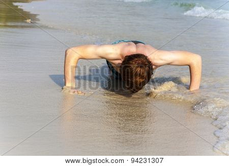 Boy At The Beautiful Beack Trains Push-ups