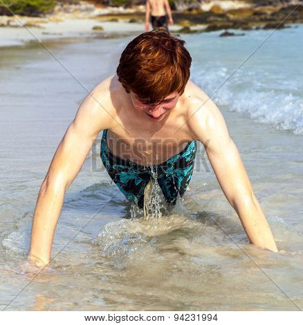 Boy At The Beautiful Beack Trains Push-ups