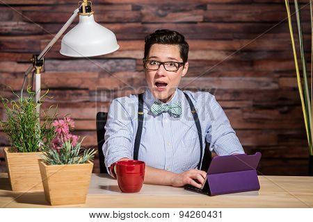 Excited Woman At Desk With Tablet