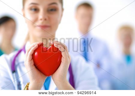 Female doctor with stethoscope holding heart .
