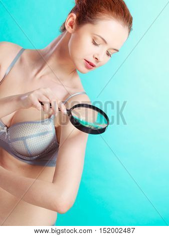 Woman Using Magnifying Glass To Examine Her Moles Skin