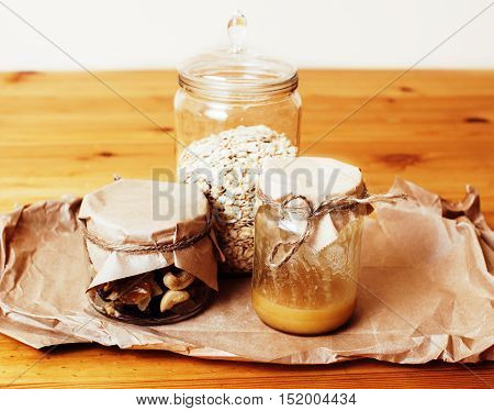 real comfort wooden kitchen with breakfast ingredients close up in glass, honey, oatmeal, milk, muesli concept