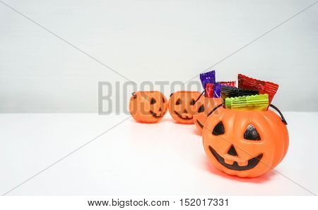 Orange pumpkin with colorful candies for Halloween party
