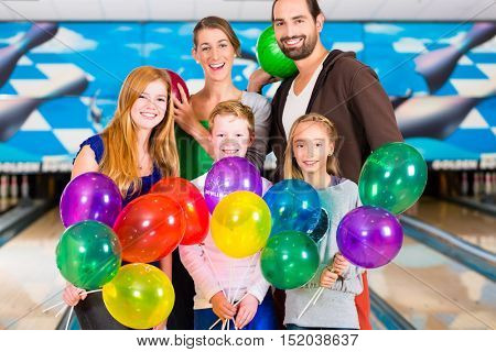 Family and friends celebrating birthday at bowling center