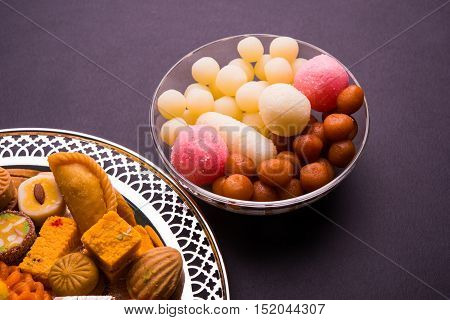Mix Mithai and diya on diwali over colourful background